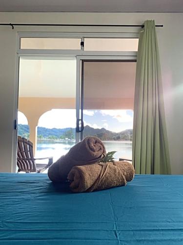 a teddy bear laying on top of a bed at Sarahlodge in Tahaa