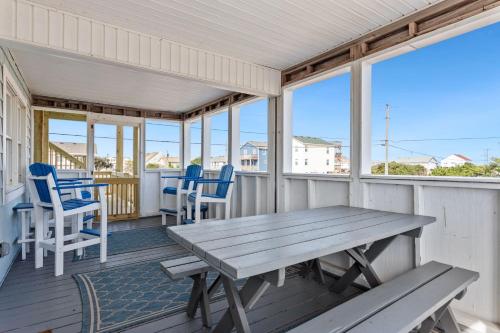 a porch with a wooden table and chairs at 4011 - The Dog`s House in Kitty Hawk