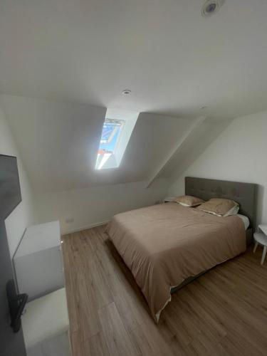 a bedroom with a bed in a attic with a window at herseaux in Mouscron