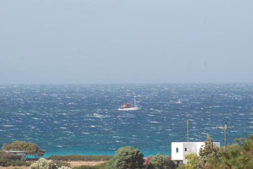 a boat floating in the water in the ocean at Scala Apartments in Kastraki Naxou