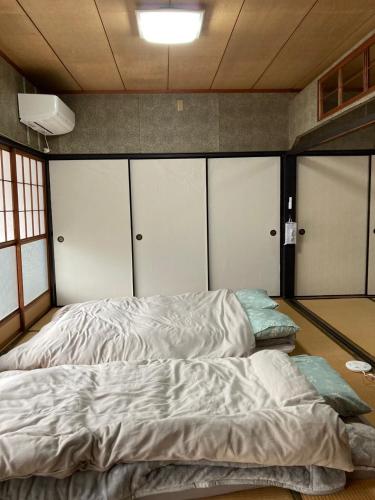 a large bed in a room with four doors at 陽だまりハウス in Hiroshima