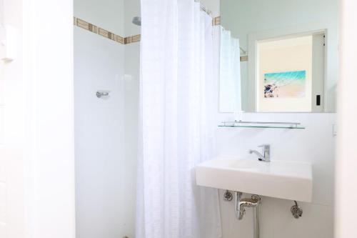 a white bathroom with a sink and a mirror at Guichen Bay Motel in Robe