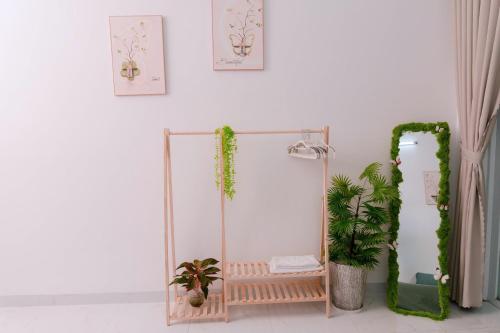 a mirror in a room with a bench and plants at HeavenVilla in Can Tho