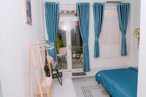 a bedroom with blue curtains and a bed at HeavenVilla in Can Tho