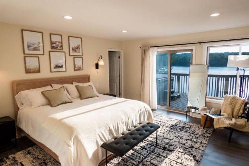 a bedroom with a large bed and a balcony at Modernist Lakefront Sojourn in Monticello