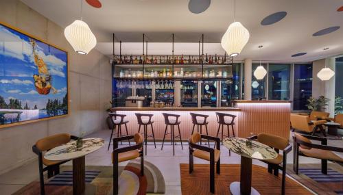 a restaurant with a bar with stools at art'otel cologne in Cologne