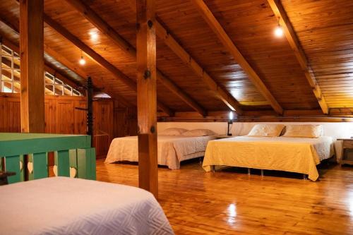two beds in a room with wooden ceilings at Sitio da Paz Celestial in Nova Petrópolis