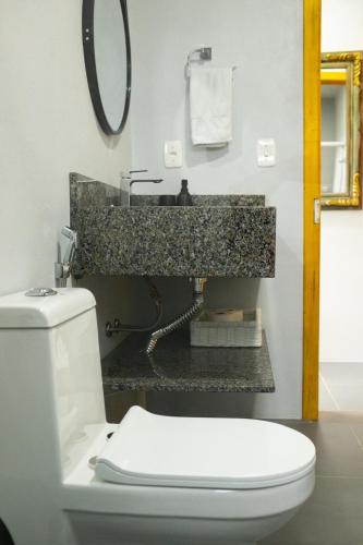 a bathroom with a white toilet and a sink at Sitio da Paz Celestial in Nova Petrópolis