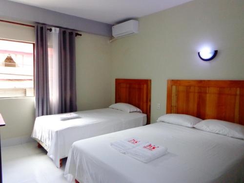two beds in a room with a window at Pampa & Selva in Rurrenabaque