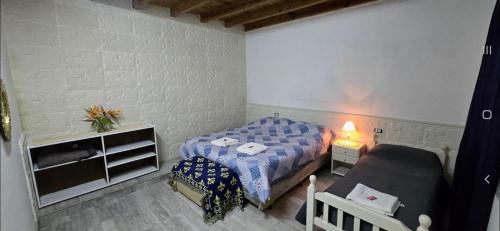 a small bedroom with a bed and a couch at Depto Pringles 1740 PB Parking Privado Gratis in Yerba Buena