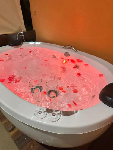 two wine glasses sitting on a bathtub covered in blood at Pousada Vale Verde com café da manhã in Lindóia