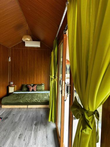 a bedroom with a green bed with a window at An's House homestay & Hagiang local tours in Ha Giang