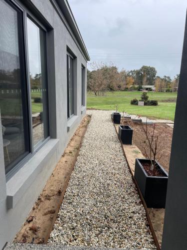 a house with a gravel path next to a window at Guinevere2 in Myrtleford