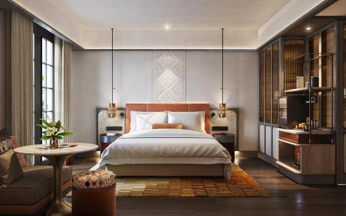 a bedroom with a bed and a couch and a table at Avani Plus Lanexang Vientiane Hotel in Vientiane