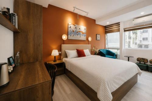 a bedroom with a bed and a desk and a window at Anchie Maison Hà Nội in Hanoi