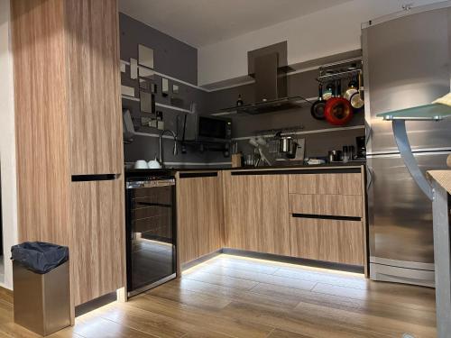 a kitchen with wooden cabinets and stainless steel appliances at iDesign Loft at Old San Juan in San Juan