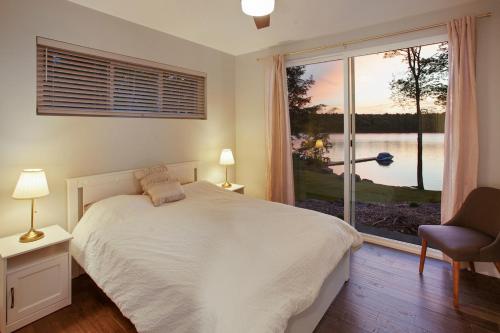 a bedroom with a bed and a large window at Lakeside Lodge with Studio Apartment in Monticello