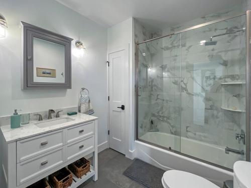 a bathroom with a glass shower and a sink at Lakeside Lodge with Studio Apartment in Monticello