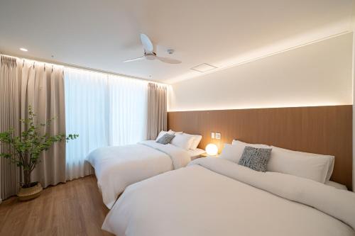 a hotel room with two beds and a window at Hotel Whooahan Suyu in Seoul
