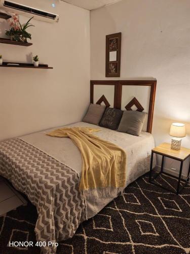 a bedroom with a bed and a table with a lamp at ZU Apartamentos in Los Algarrobos