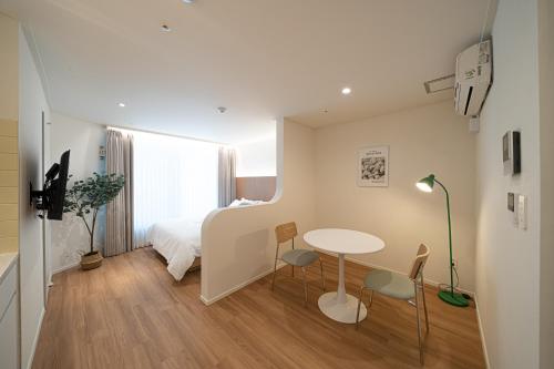 a small room with a bed and a table and chairs at Hotel Whooahan Suyu in Seoul