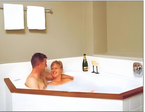 a man and woman sitting in a bath tub at Off Broadway Motel in Auckland