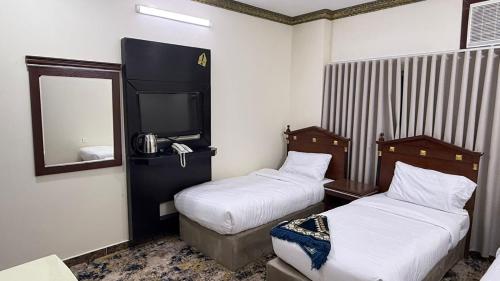 a hotel room with two beds and a mirror at صالة المدينة 2 in Medina