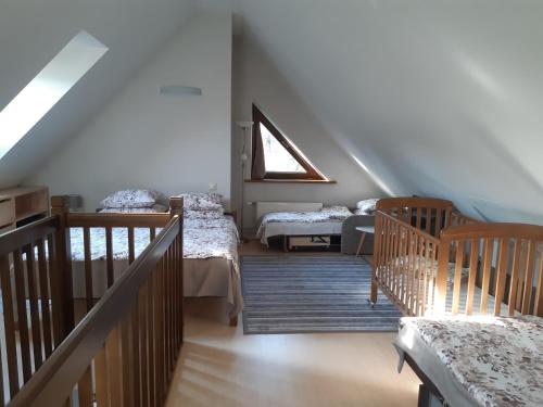 a attic room with two beds and a window at Lazdas in Saulkrasti