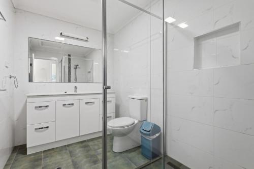 a bathroom with a toilet and a glass shower at Villa 30 Tangalooma in Tangalooma