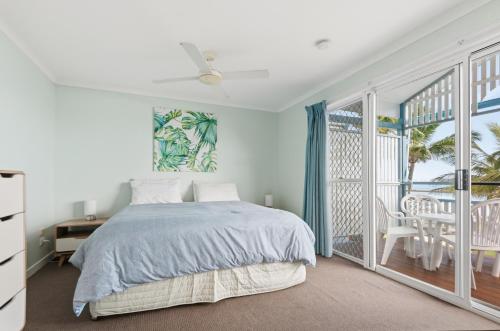 a bedroom with a bed and a balcony at Villa 30 Tangalooma in Tangalooma