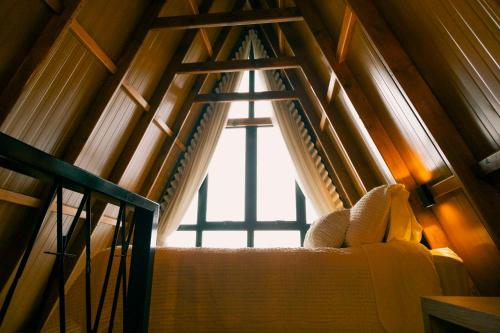 a window in a room with a bed and a staircase at Cabanas Monte Cristo in Serafina Corêa
