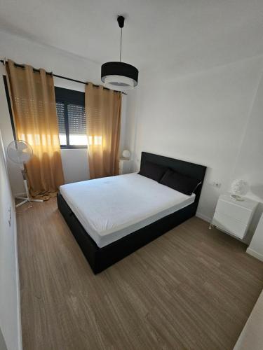a bedroom with a white bed and a window at Palmarejo grande in Praia