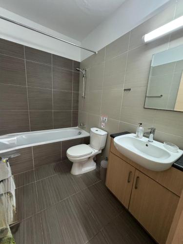a bathroom with a white toilet and a sink at Amigos Apartment Mythical in Protaras
