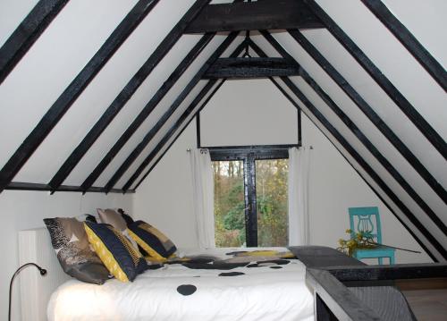 Bett in einem Zimmer mit Fenster in der Unterkunft De Hagmolenbeek Boekelo in Boekelo