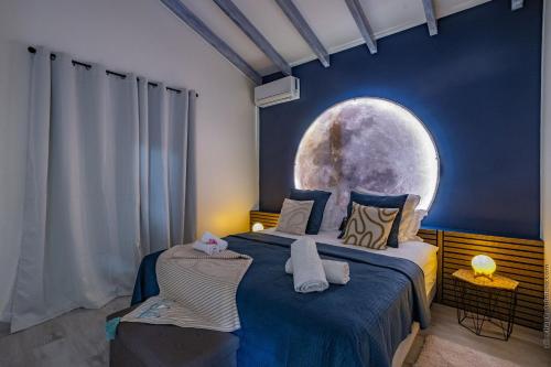 a bedroom with a bed with a moon mural on the wall at La Villa de Solange - Azur in La Trinité