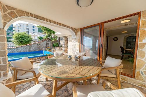 a patio with a table and chairs and a pool at Vila Dora in Dobra Voda