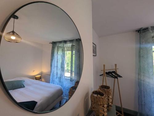 a mirror in a bedroom with a bed and a window at L'ecole buissonnière in Riaucourt