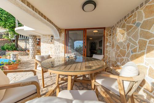 a patio with a wooden table and chairs at Vila Dora in Dobra Voda