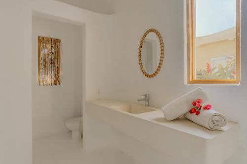 a white bathroom with a sink and a towel at Casa Brasil Careyes in Careyes