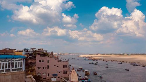 a view of a river with buildings and a beach at Kashiyana in Varanasi