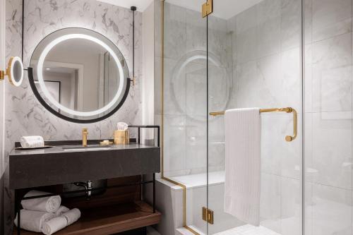 a bathroom with a sink and a shower with a mirror at Caesars New Orleans, A Caesars Rewards Destination in New Orleans