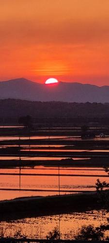a sunset over a body of water with the sun at Paju Seolreda in Paju
