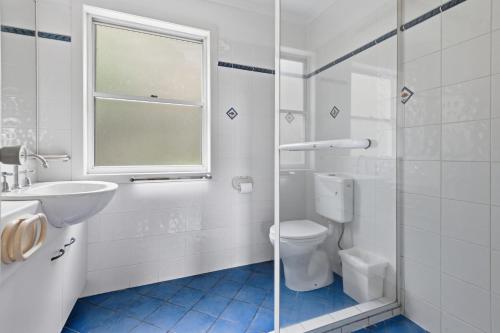 a bathroom with a toilet and a sink and a shower at Villa 31 Tangalooma Beach Front in Tangalooma