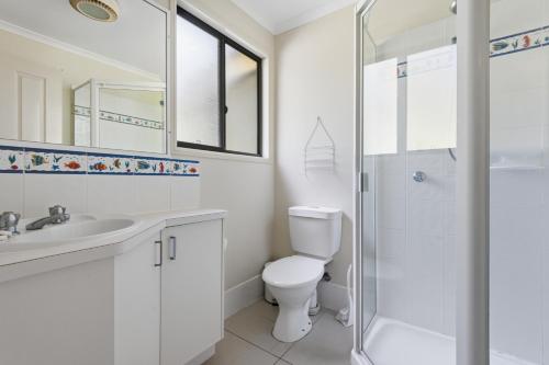 a bathroom with a toilet and a sink and a shower at Quandamooka Beach House in Bulwer