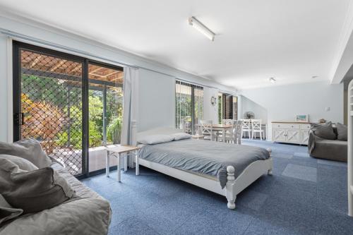 a bedroom with a bed and a living room at Quandamooka Beach House in Bulwer