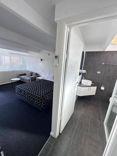a bedroom with a bed and a couch in a room at Charles Sturt Motor Inn in West Wyalong