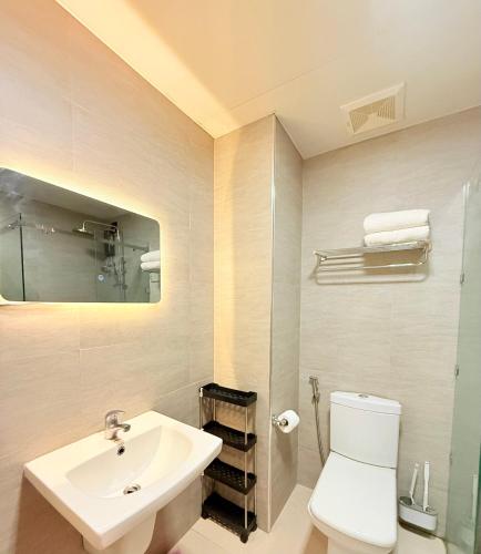 a bathroom with a sink and a toilet and a mirror at Antara Residential Condominium in Talisay