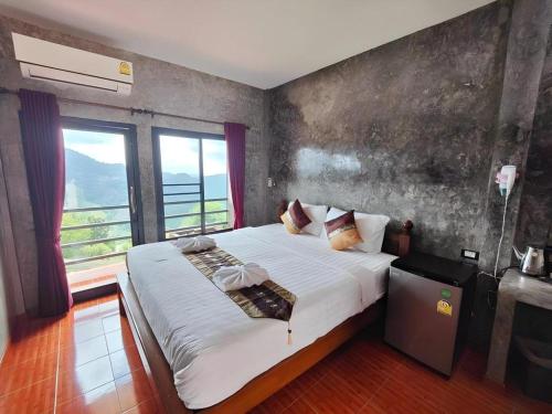 a bedroom with a large bed with a large window at 101 Tea Green View in Mae Salong
