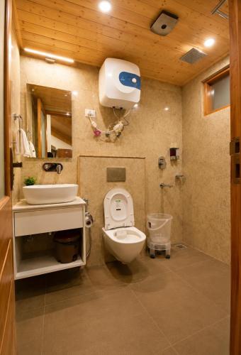 a bathroom with a toilet and a sink at The Alpine Escape, Manali - A Beautiful Cottage in Cloud's in Manāli