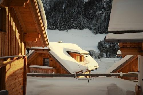 a cabin with snow on the roof of it at Bergdorf Riesner in Donnersbachwald